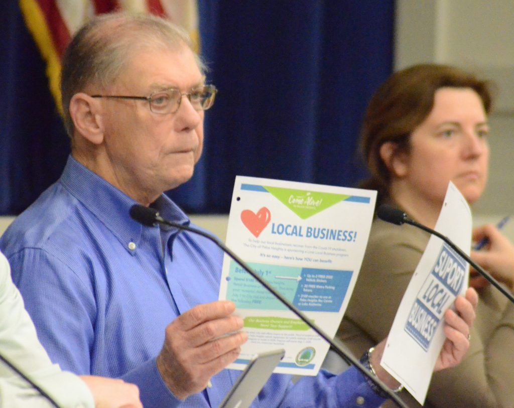 Palos Heights Alderman Jerry McGovern holds up fliers about helping local businesses during a special meeting regarding video gaming. (Photos by Jeff Vorva)