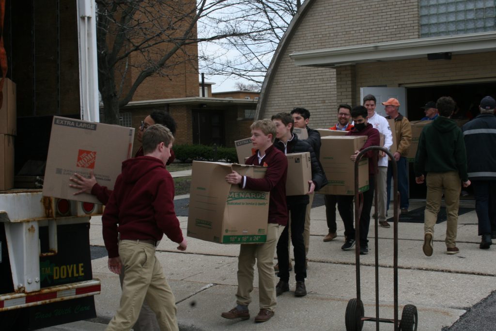 Brother Rice High School students help carry boxes of supplies outside St. Bernadette Parish in Evergreen Park that will eventually be sent overseas to Poland to assist the residents of Ukraine, many of whom are homeless due to invasion of their country by Russia. (Photos by Joe Boyle)