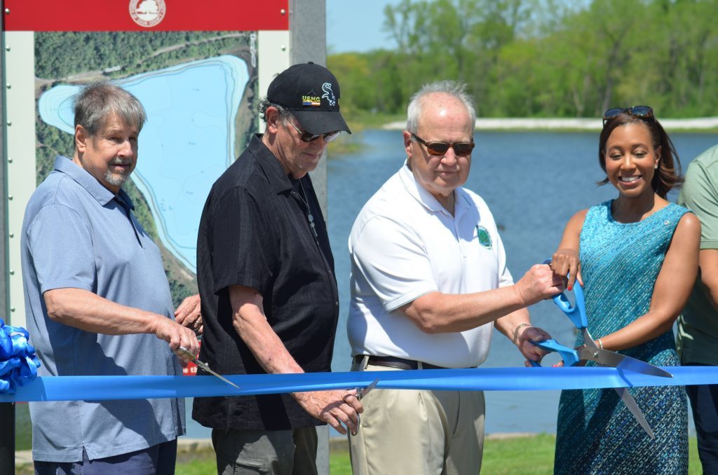 Palos Heights Aldermen Don Bylut (from left) and Jack Clifford, Mayor Bob Straz and Metropolitan Water Reclamation District President Kari Steele cut the ribbon to celebrate flood improvements at Arrowhead Lake on Friday. (Photo by Jeff Vorva)