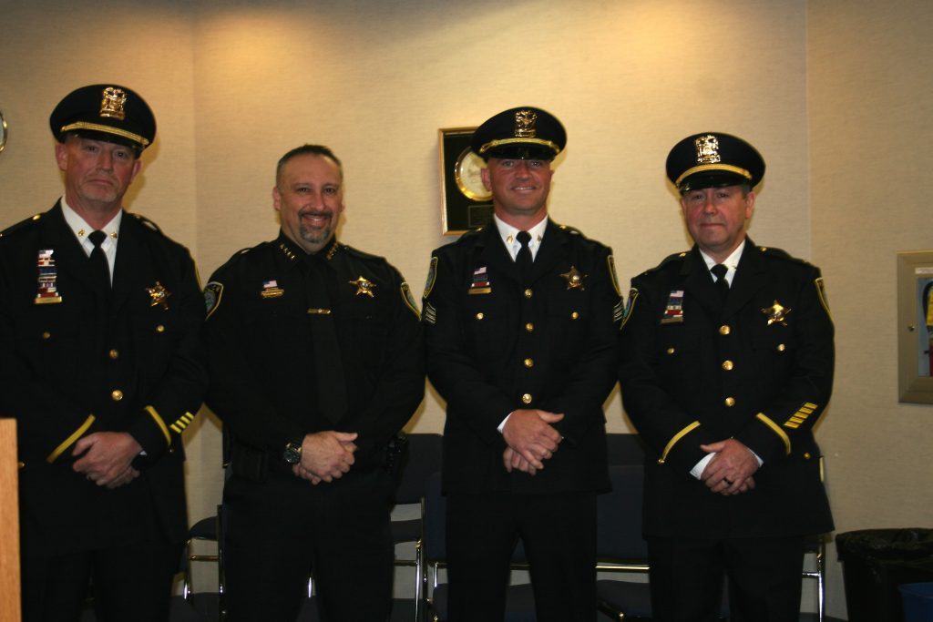 Oak Lawn Police Chief Dan Vittorio (second from left) congratulates members of the police department who received promotions and were officially sworn in at the village board meeting Tuesday. They are (from left) Cmdr. Edward Clancy, Sgt. Finbarr Haran and Lt. Michael Hudziak. (Photo by Joe Boyle)