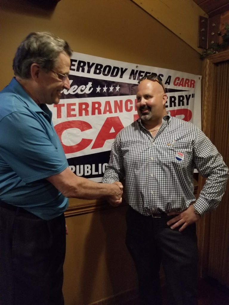 Lyons Township Democratic Committeeman Steve Landek (left) congratulates Terry Carr Tuesday night at Carr's victory celebration in McCook (Photo by Carol McGowan)