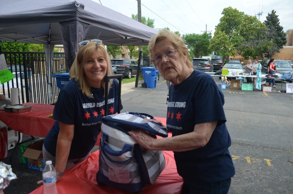 Wearing their Garfield Ridge Strong shirts, Arlene White (right) and Michele Doherty work the most recent Sell-A-Bration event near 57th and Narragansett. --Photo by Joan Hadac