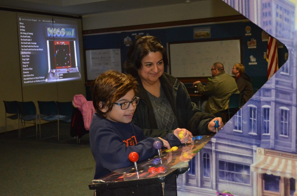 In this photo from 2017, Donny Del Raso, 9, enjoys a Teenage Mutant Ninja Turtles arcade game, as his mom, Carol, watches. -- File photo