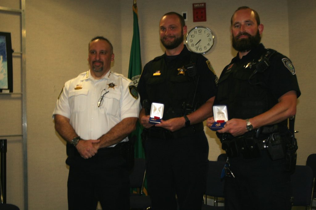 Oak Lawn Police Chief Dan Vittorio (from left) presents Life Saving Awards to Sgt. Sean Heilig and Officer Matthew Atkinson for providing medical attention to a man who suffered gunshot wounds. The awards were presented during the Oak Lawn Village Board meeting Tuesday night. The actions of Heilig and Atkinson most likely saved the victim's life, according to hospital staff. (Photo by Joe Boyle)