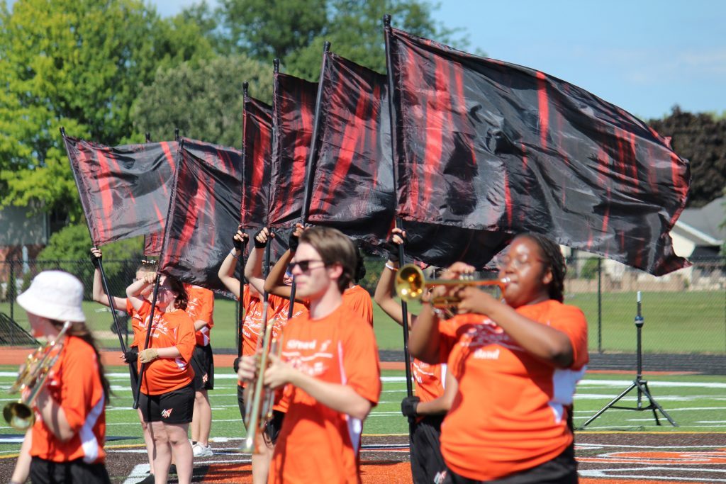 With the color guard flags whipping in the breeze, the Shepard High School marching band rehearses their new field show. (Supplied photos)