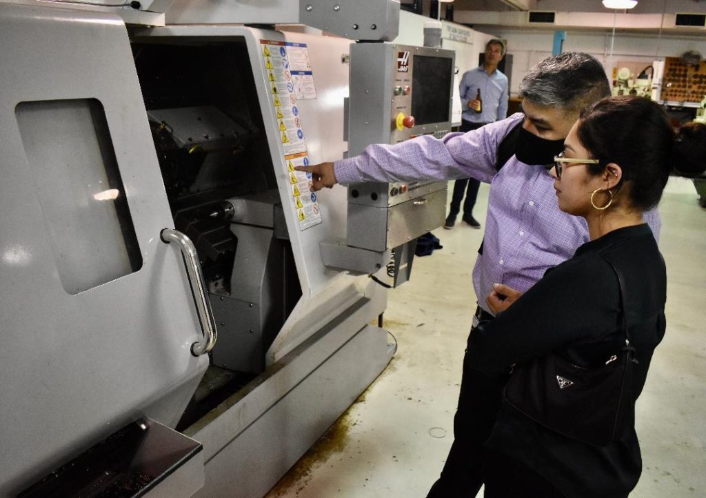 Daley College instructor Juan Martinez discuss a Computerized Numerical Control lathe with Diana Trujillo, workforce engagement director at Greater Southwest Development Corporation. --Greater Southwest News-Herald photo by Steve Metsch