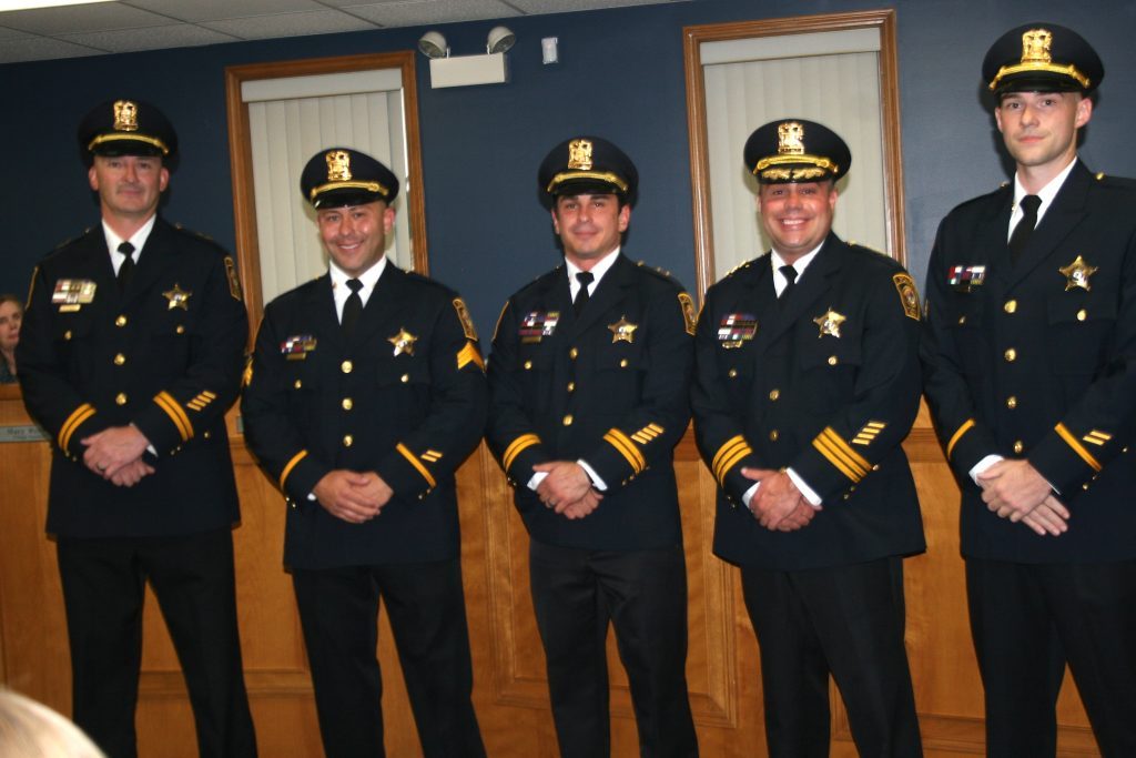 Michael Cozzi (second from left) and Nicholas Boynton (fourth from left) were promoted to sergeants during the Worth Village Board meeting on Tuesday night. They were congratulated by (from left) deputy chiefs Chis Fernandez and Rob Petersen, and Police Chief Tim Denton. (Photo by Joe Boyle)