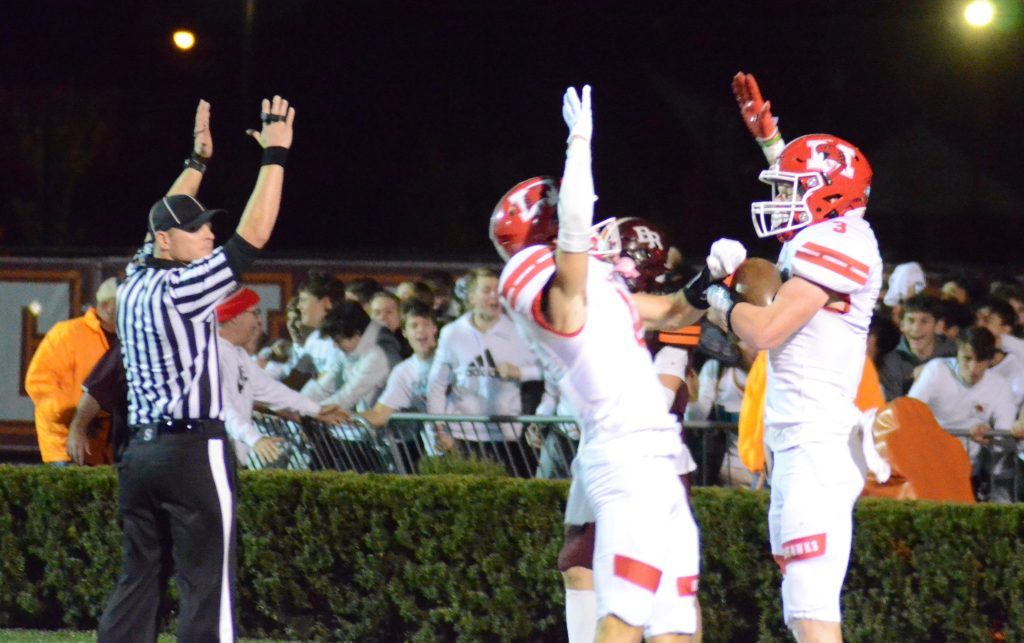 Arms are raised by (left-to-right) the referee, Nolan Baudo and Mike Donegan after Donegan's touchdown reception against Brother Rice Friday night. Photo by Jeff Vorva