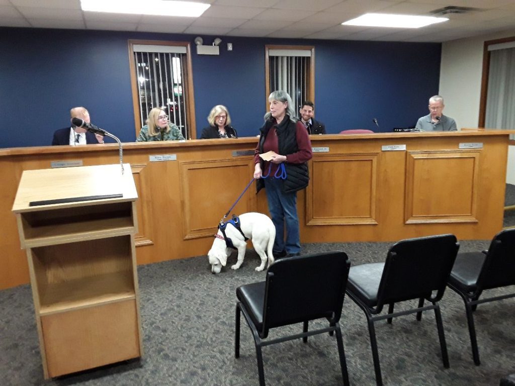 Shireen O'Brien, a Marine veteran, is accompanied by her service dog, Riley, during the Worth Village Board meeting Tuesday night. O'Brien thanked the board and everyone who provided donations that allowed her to purchase the dog. (Photo by Joe Boyle)