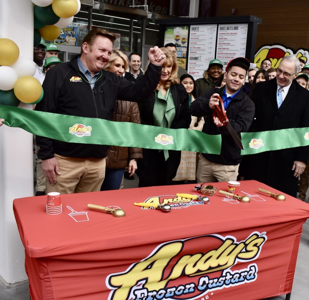 Andy Kuntz, CEO and owner of Andy’s Frozen Custard (left) and La Grange Park Mayor Jim Discipio (right) cheer as store manager Ruben Rodriguez cuts the grand-opening ribbon. (Photos by Steve Metsch)