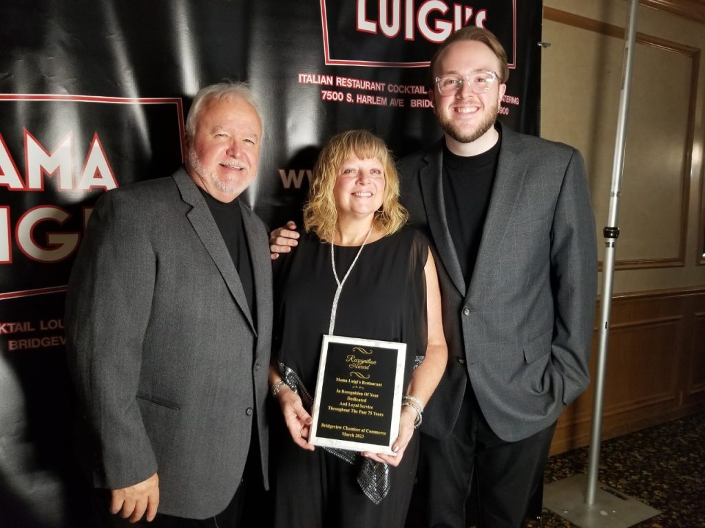 Owners of Mama Luigi's (from left) James Talerico, his wife Victoria Talerico and their son, General Manager Dominic Talerico, with an award presented to them by the Bridgeview Chamber of Commerce acknowledging the restaurant's 75th Annviersary. (Photos by Carol McGowan)