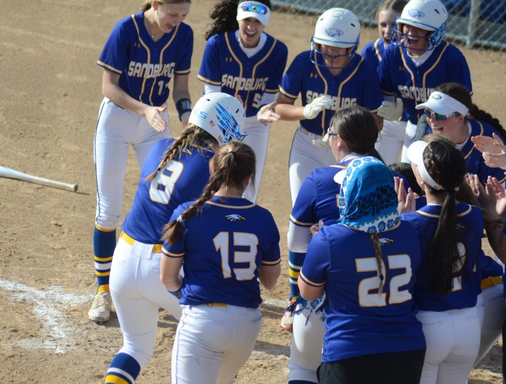 Zoe Jeanes (8) is about to get mobbed by her Sandburg teammates after hitting a home run against Homewood-Flossmoor on April 18. Photo by Jeff Vorva