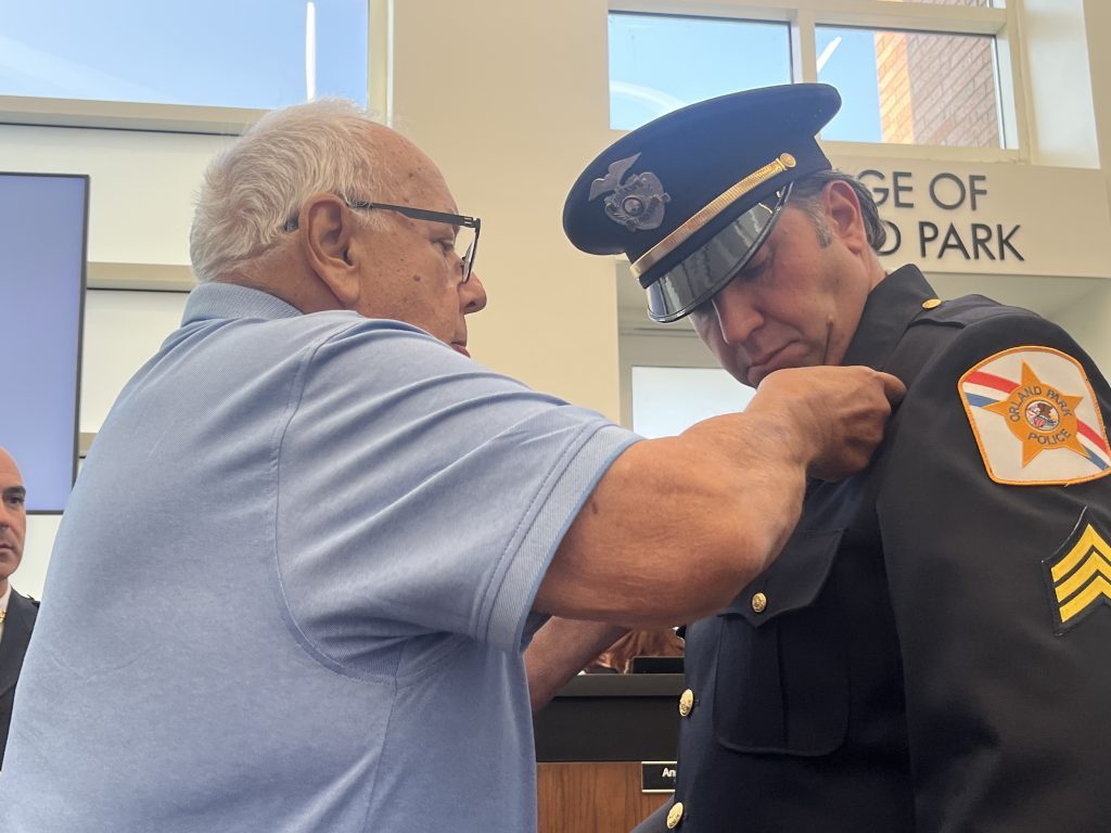 Norm Staszak pins a badge on his son, David's lapel as David was promoted to sergeant in a ceremony July 17. (Photos by Jeff Vorva)