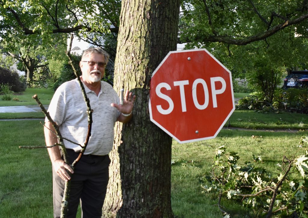 Ed Krzeminski shows off the stop sign imbedded in a tree in his front yard on Lorraine Drive. (Photos by Steve Metsch)