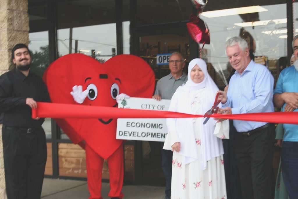 Palos Hills Mayor Jerry Bennett cuts the ribbon to celebrate the official grand opening of Turkish House on August 5. On hand for the ceremony were (from left) employee Ayhem Abutahoua, Ruby, the Palos Hills mascot; Ald. Mike Price (1st), and Sundus Abutahoua, one of the owners. (Photos by Joe Boyle)